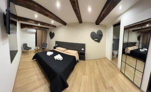 a bedroom with a black bed with hearts on the wall at Residenza De Rose 2 in Cosenza