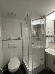 a bathroom with a shower and a toilet and a sink at Advantage Appartements Hotel in Nuremberg +43 photos