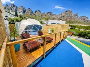 a wooden deck with chairs and a gazebo at VistaBlu Camps Bay in Cape Town
