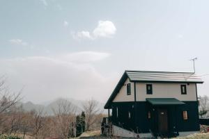 a black and white house with a green door at Lakeview Etsu in Lake Toya