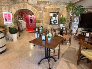 a restaurant with tables and a stone wall at Hotel El Refugio 3 estrellas in Cóbreces