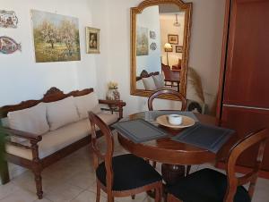 a living room with a couch and a table and a mirror at Sophisticated Central House Tinos in Tinos