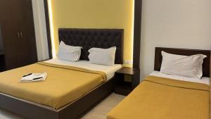 a hotel room with two beds and a mirror at Jerry's Chateau in Pondicherry