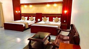 a hotel room with two beds and a table at ROYAL RESIDENCY Ac in Virudunagar