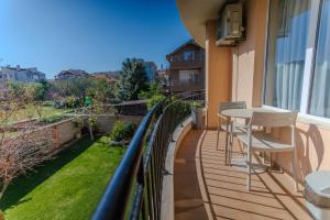 a balcony with a table and chairs on a building at Family Hotel Deja Vu in Ravda