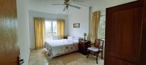 a bedroom with a bed and a chair and a window at Rivers Rest in Seafield