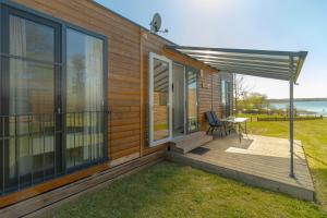 a house with a deck with a table and a patio at Sonnenkap Camping in Prenzlau +19 photos
