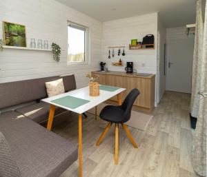 a living room with a table and a chair at Sonnenkap Camping in Prenzlau