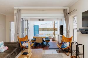 a living room with a couch and a table and chairs at Sterretjie in Paternoster