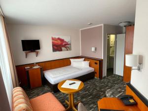 a hotel room with a bed and a tv at Advantage Appartements Hotel in Nuremberg