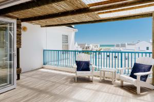 a balcony with two chairs and a view of the ocean at Sterretjie in Paternoster