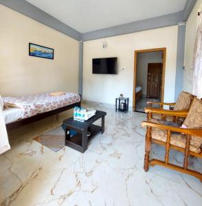 a living room with a couch and a table at esS PHLYNDA Inn in Lāitlyngkot