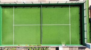 a green tennis court in the middle of a building at Caybeach Meloneras in Meloneras