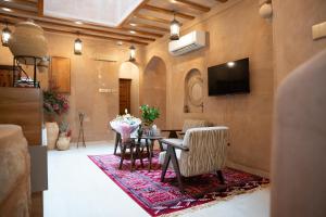 a living room with a table and chairs and a television at بيت المقصرة Almuqasrah house in Nizwa