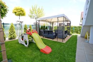 a playground with a slide on the grass at Chmielowa2 - Apartamenty in Rowy +35 photos