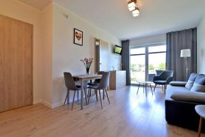 a living room with a couch and a table and chairs at Chmielowa2 - Apartamenty in Rowy