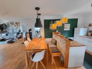 a kitchen and living room with a wooden table and a dining room at Ferienwohnung am Sendberg in Frielendorf