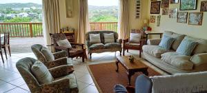 a living room with couches and chairs and a balcony at Rivers Rest in Seafield +20 photos
