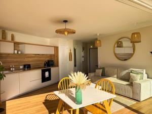 a living room with a table and a couch at La Tour Alba in Valras-Plage +13 photos