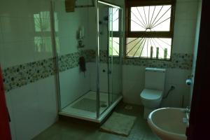 a bathroom with a shower and a toilet and a sink at Good Times in Kampala +54 photos