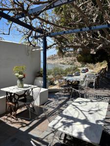 a group of tables and chairs on a patio at Endless Blue Studios in Myrtos