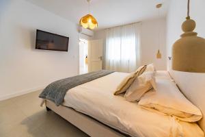 a bedroom with a bed and a tv on the wall at Casa Dara's Sea in Playa Honda