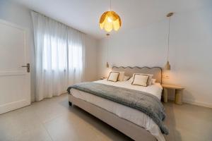 a bedroom with a large bed and a chandelier at Casa Dara's Sea in Playa Honda