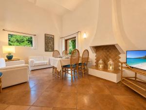 a living room with a table and a tv at Alba Ruja Residence 2 with Pool Close to All Amenities in Porto Cervo