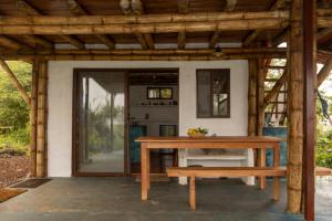 a table and bench in front of a house at Highland Bamboo Cabin, San Cristóbal Galápagos in San Cristóbal