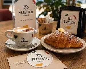 a table with a cup of coffee and a croissant at Una Baita nel Centro di Pescara con Parcheggio Privato - Palazzo Carolina in Pescara