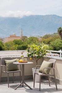 a table and chairs on a balcony with a view at Zest House Pompei in Pompei