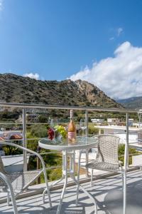 a table with a bottle of wine on a balcony at Faflagos Apartments in Psari Forada
