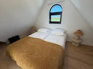 a bedroom with a bed and an attic window at 8 persons Wellness Villa Tulpenacker in Roelofarendsveen +30 photos