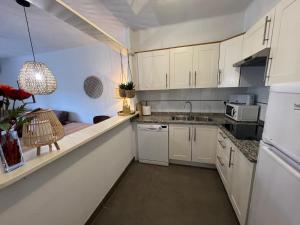 a small kitchen with white cabinets and a sink at Breda 2b in L'Estartit