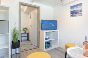 a living room with a tv and a table at Alte Dorfstraße 29 REETungsinsel in Behrensdorf