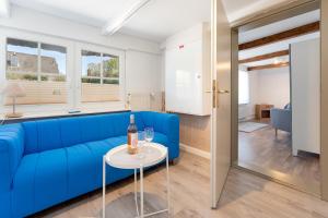 a living room with a blue couch and a table at Alte Dorfstraße 29 REETungsinsel in Behrensdorf +20 photos