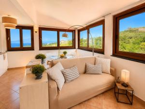 a living room with a couch and some windows at Villa Rosmary in Massa Lubrense