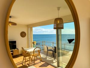 a mirror in a room with a view of the ocean at La Tour Alba in Valras-Plage