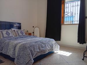 a bedroom with a bed and a window at Tafoukt House in Aourir