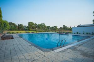 a large swimming pool with blue water at Wildernest Resort in Kota Bāgh