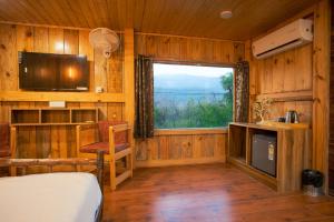 a bedroom with a bed and a window and a television at Wildernest Resort in Kota Bāgh