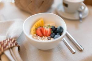 a bowl of cereal and fruit on a table at B&B GoldRain in Coldrano