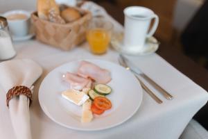 a white plate with food on a table at B&B GoldRain in Coldrano