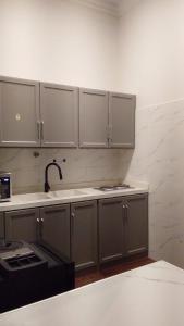 a kitchen with gray cabinets and a sink at اليمامه in Al Yamāmah