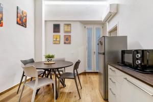 a kitchen and dining room with a table and a refrigerator at Ser Lapo - Dimora storica a Prato in Prato