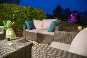 a patio with two wicker chairs and a couch at L'Orée in Turckheim
