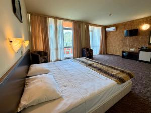 a bedroom with a large bed with a large window at Hotel Amaris in Sunny Beach