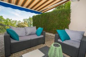 two wicker chairs on a patio with blue pillows at L'Orée in Turckheim +24 photos