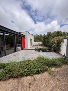 a house with a patio and a building with windows at La Maison des Eléphants in Vivonne