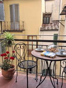 a table and chairs sitting on a balcony at Fashion Florence Rooms in Florence